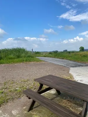 a wooden picnic table sitting on the side of a road at Nieuwendijk hoeve in Oud-Ade