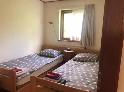 two twin beds in a room with a window at Enjoyable holiday home in Noordwijk