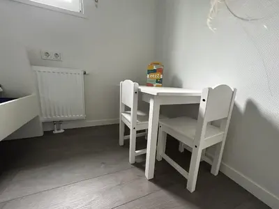 a small white table and chairs in a room at Bungalowpark de Horn - Floresta 213 in Dirkshorn