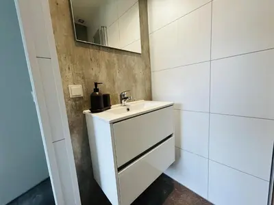 a white bathroom with a sink and a mirror at Bungalowpark de Horn - Floresta 213 in Dirkshorn