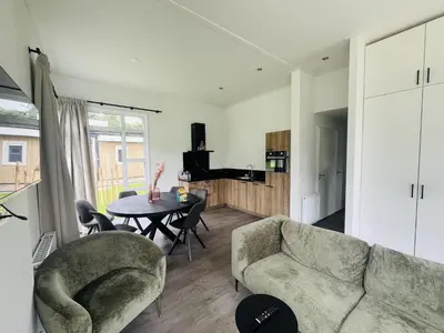a living room with a couch and a table at Bungalowpark de Horn - Floresta 213 in Dirkshorn