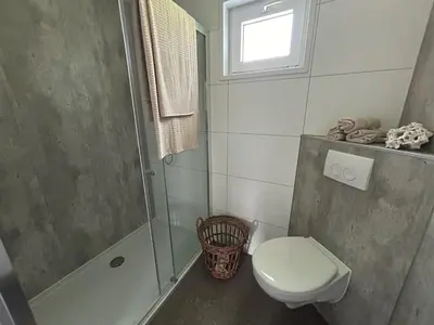 a bathroom with a shower and a toilet and a sink at Bungalowpark de Horn - Floresta 214 in Dirkshorn