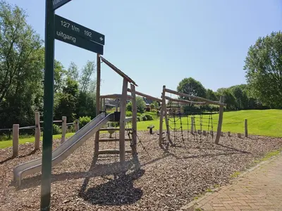 a playground with a slide in a park at Bungalowpark de Horn - Floresta 214 in Dirkshorn