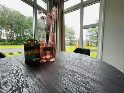 a table with a vase with flowers and a box on it at Bungalowpark de Horn - Floresta 215 in Dirkshorn