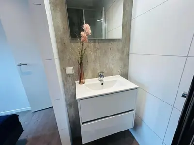 a bathroom with a sink and a vase with a flower at Bungalowpark de Horn - Floresta 215 in Dirkshorn