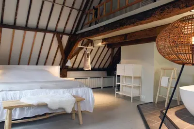 a bedroom with a white bed and a wooden ceiling at Huis met de Kogel in Alkmaar