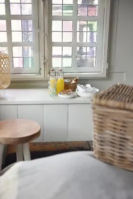 a kitchen counter with a table and a basket and windows at Huis met de Kogel in Alkmaar
