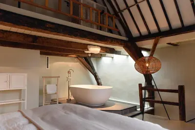 a bedroom with a bed and a large bowl on a table at Huis met de Kogel in Alkmaar