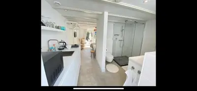 a bathroom with a sink and a shower and a toilet at Tranquil Guest House in Zandvoort