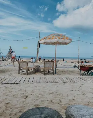 a beach with two benches and an umbrella at Tranquil Guest House in Zandvoort