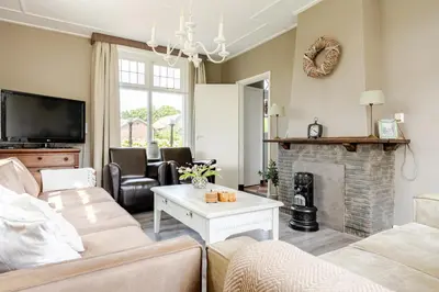 a living room with a couch and a fireplace at Gastenverblijf in het voorhuis van onze woonboerderij in Maartensdijk