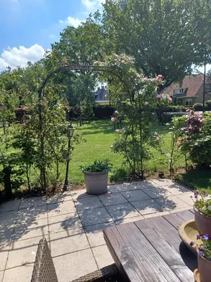 a garden with a wooden table and some plants at Gastenverblijf in het voorhuis van onze woonboerderij in Maartensdijk