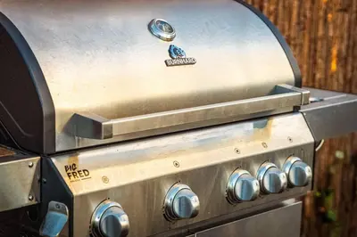 a close up of a gas stove with a grill at Waterfront tiny home with spacious garden in Vinkeveen