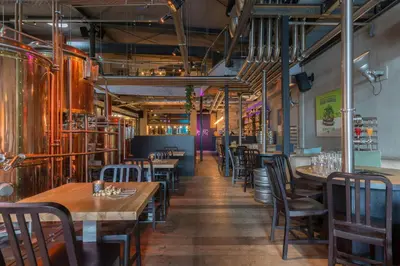 a dining room with wooden tables and chairs at Leonardo Hotel Almere City Center in Almere