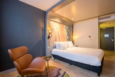 a hotel room with a bed and a chair at Leonardo Hotel Almere City Center in Almere