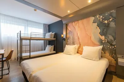 a bedroom with a bed and a bunk bed at Leonardo Hotel Almere City Center in Almere