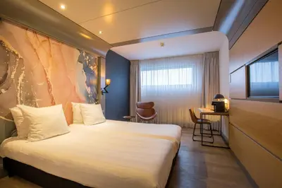 a hotel room with a bed and a window at Leonardo Hotel Almere City Center in Almere