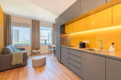 a kitchen with a sink and a living room at Limehome Amsterdam Gatwickstraat in Amsterdam