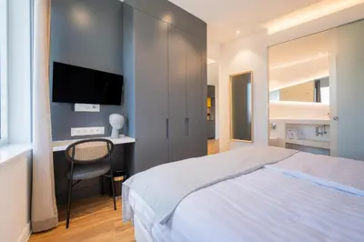 a bedroom with a bed and a desk and a television at Limehome Amsterdam Gatwickstraat in Amsterdam