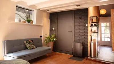 a living room with a couch and a brick wall at Beach House Sea La Vie 50 meters from the beach in Zandvoort