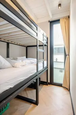 two bunk beds in a room with a window at Moderne houseboat op het water! in Assendelft