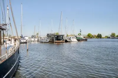 a bunch of boats are docked in a harbor at Moderne houseboat op het water! in Assendelft