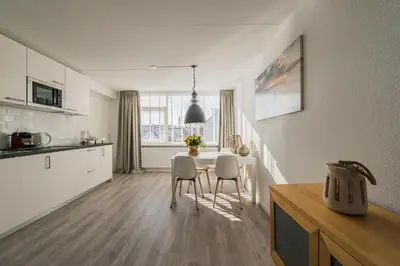 a kitchen and dining room with a table and chairs at Strand 122 Appartement in Egmond aan Zee