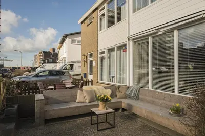a couch sitting in front of a building at Strand 122 Appartement in Egmond aan Zee