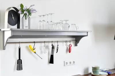 a shelf with utensils hanging on a wall at Pronkhuisje in Oterleek
