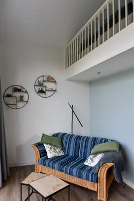 a living room with a blue couch and a staircase at Pronkhuisje in Oterleek