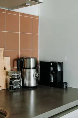 a kitchen counter with a coffee pot and a microwave at Etoile31 seaside apartment Egmond aan Zee in Egmond aan Zee