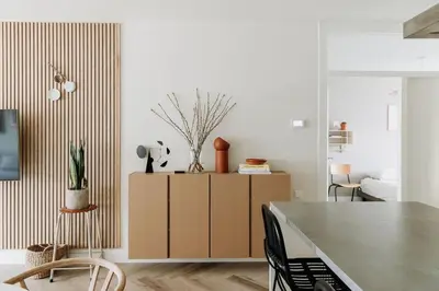 a living room with a cabinet with plants on it at Etoile31 seaside apartment Egmond aan Zee in Egmond aan Zee