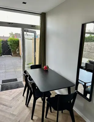 a dining room with a black table and chairs at Eight in Zandvoort