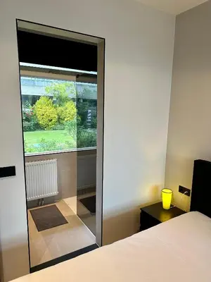 a bedroom with a large glass door with a window at Eight in Zandvoort