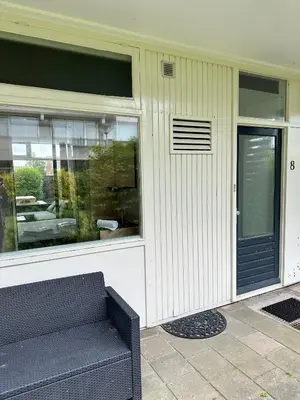 a building with a couch in front of a window at Eight in Zandvoort