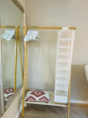 a bunk bed with a ladder next to a mirror at Cosy summerhouse in Noordwijk aan Zee