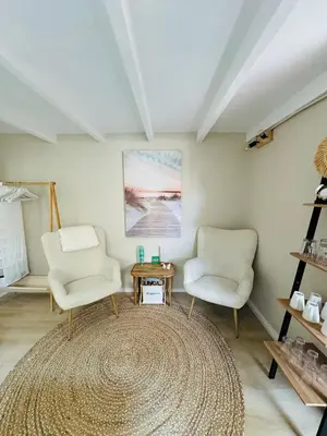 a living room with two chairs and a rug at Cosy summerhouse in Noordwijk aan Zee