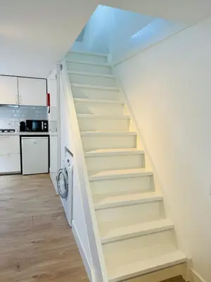 a staircase leading up to a kitchen in a house at Zomerhuis - Gratis parkeren! in Noordwijk aan Zee