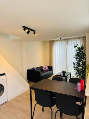 a living room with a table and a couch at Zomerhuis - Gratis parkeren! in Noordwijk aan Zee