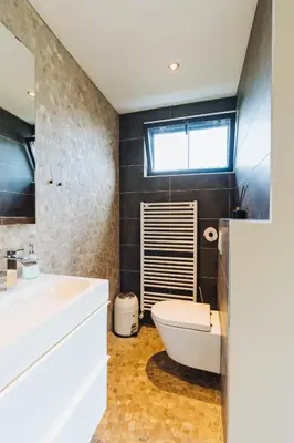 a bathroom with a sink and a toilet and a window at Sfeervol luxe appartement Haarlemmerhout bij Haarlem Centrum en Amsterdam - gratis parkeren in Haarlem