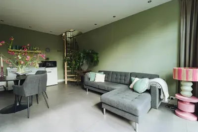 a living room with a couch and a table at Sfeervol luxe appartement Haarlemmerhout bij Haarlem Centrum en Amsterdam - gratis parkeren in Haarlem