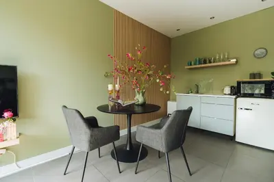 a kitchen with a table with chairs and a vase with flowers at Sfeervol luxe appartement Haarlemmerhout bij Haarlem Centrum en Amsterdam - gratis parkeren in Haarlem