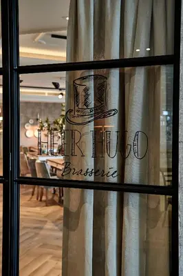 a window of a restaurant with a sign on it at Hotel Heer Hugo in Heerhugowaard