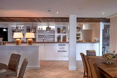 a dining room with a table and chairs and a bar at Hotel Heer Hugo in Heerhugowaard