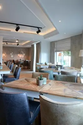 a dining room with a large table and chairs at Hotel Heer Hugo in Heerhugowaard