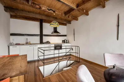 a kitchen with white cabinets and wooden ceilings at Turfhuys aan het Spaarne in Haarlem