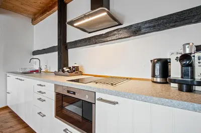 a kitchen with white cabinets and a stove top oven at Turfhuys aan het Spaarne in Haarlem
