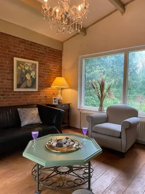 a living room with a couch and a table at Villa bij bos en centrum in Bergen