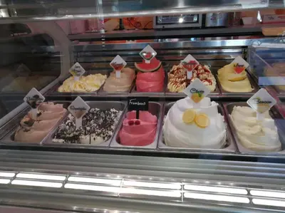 a display case filled with lots of different types of cakes at Villa bij bos en centrum in Bergen