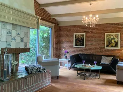 a living room with a couch and a fireplace at Villa bij bos en centrum in Bergen